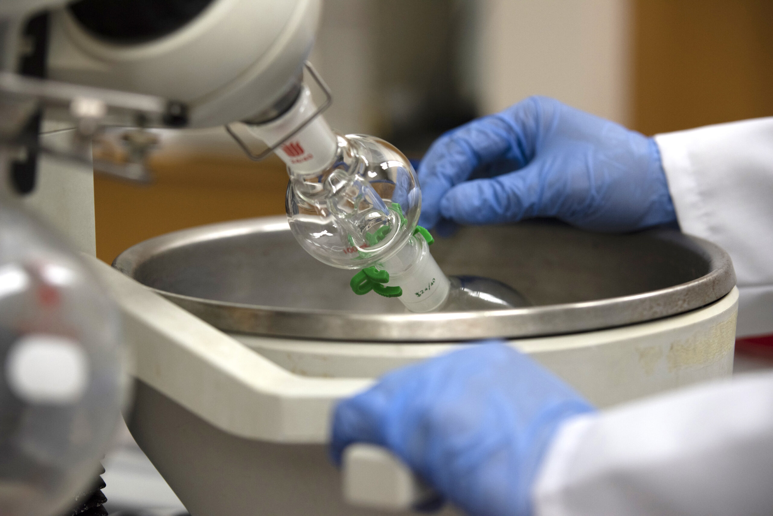 A close-up of the rotary evaporator shows the glass chambers used to heat and concentrate samples.