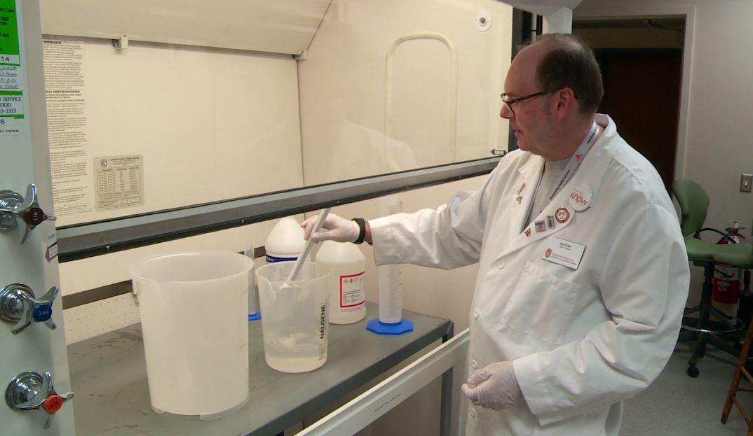 Ed Elder stirring hand sanitizer solution in a fume hood