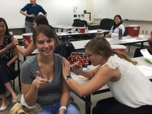 Maren VanMieghem receiving flu shot from Christine Wacek