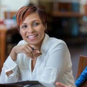 A smiling professional continuing education student converses with other participants