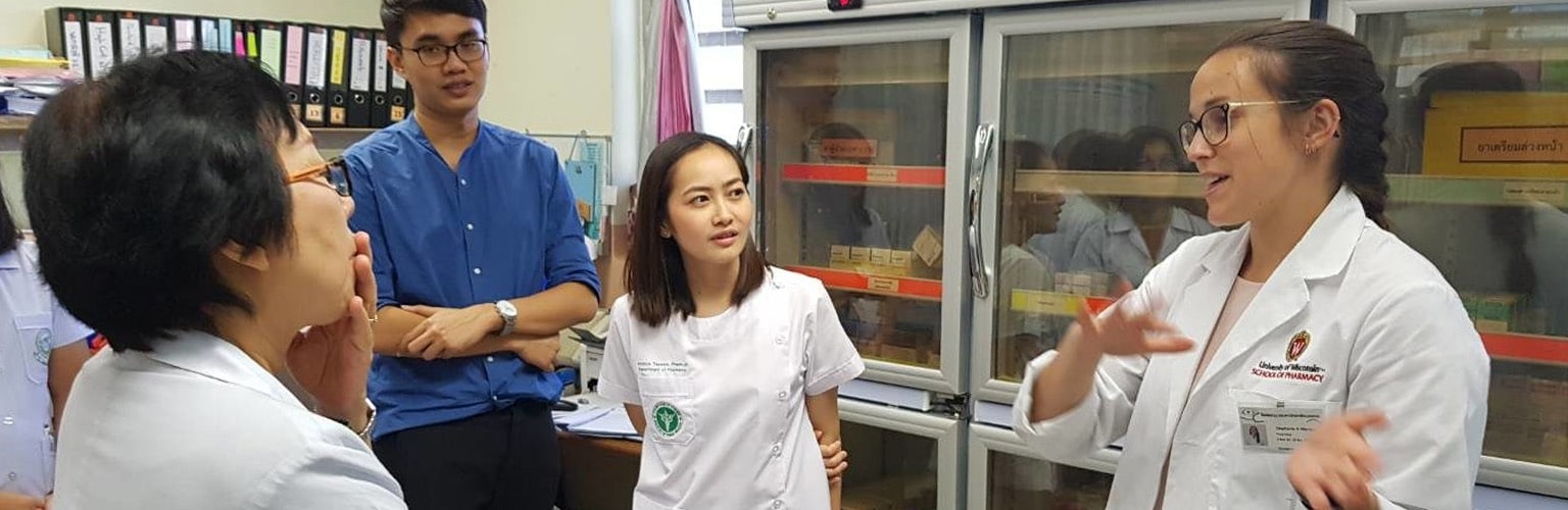 A UW-Madison pharmacy student chats with colleagues at a rotation in Thailand
