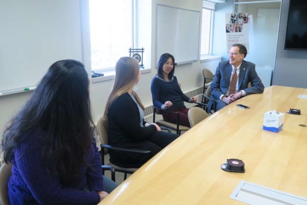Michelle Chui speaking in a meeting with Provost Karl Scholz and graduate students listening