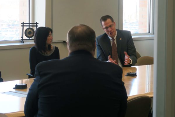 Provost Karl Scholz speaking and gesturing with his hands at the table during a meeting with staff
