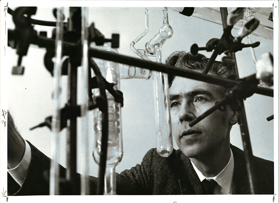 Jens Carsensen stands behind an array of test tubes