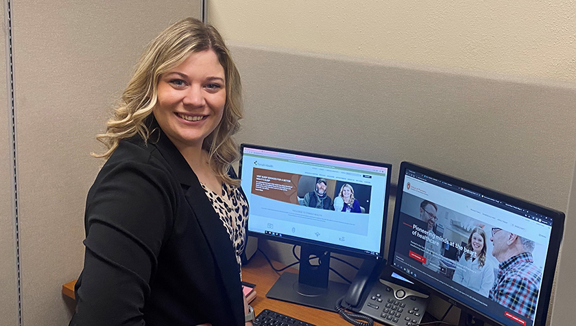 Kendra Isberner smiling at a desk with computers
