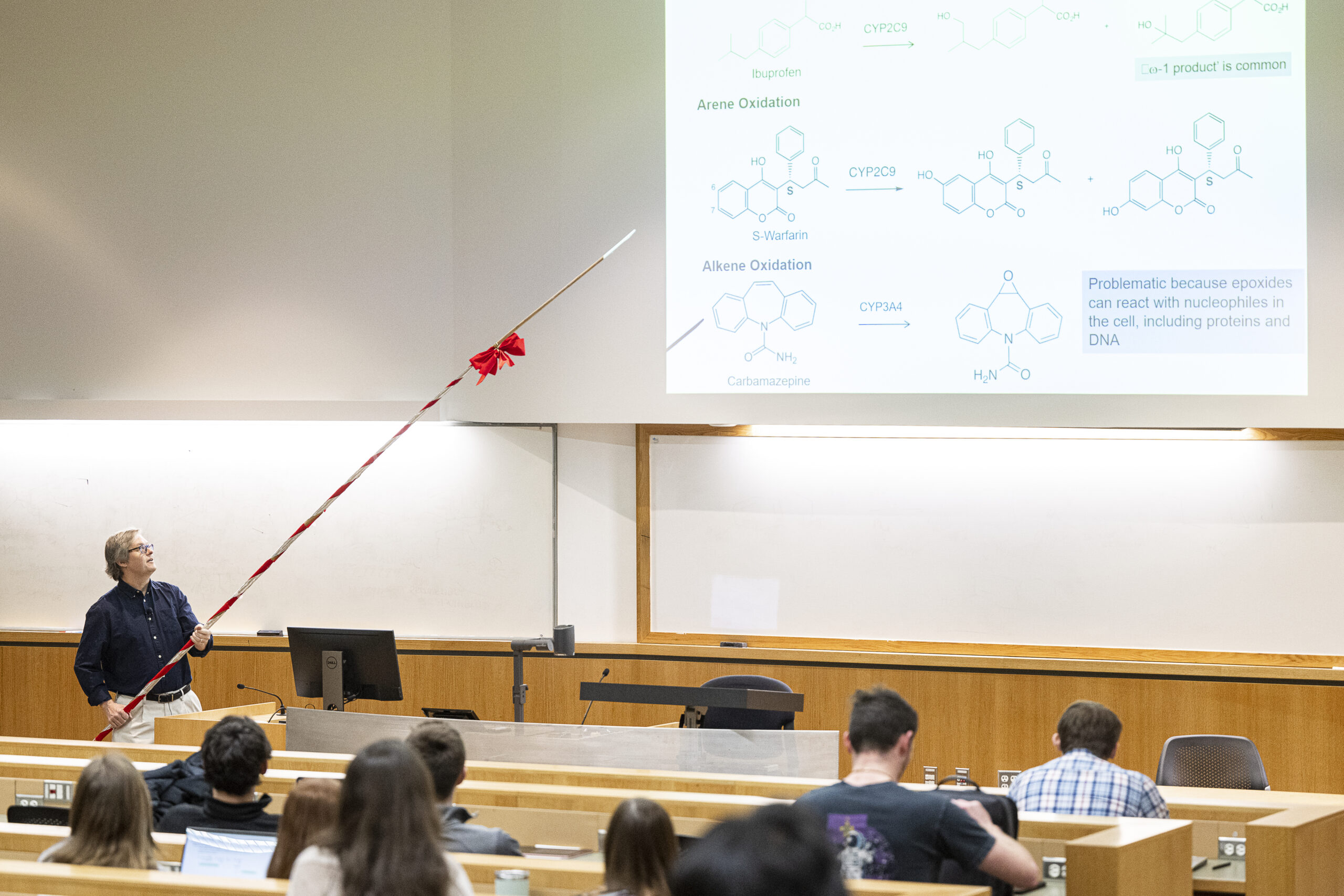 Charles Lauhon uses his 20-foot-long wooden pointer to gesture across the screen from the overhead projector. Photo by Bryce Richter