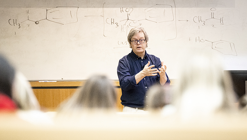 Charles Lauhon stands in front of a white board teaching a course. Photo by Bryce Richter