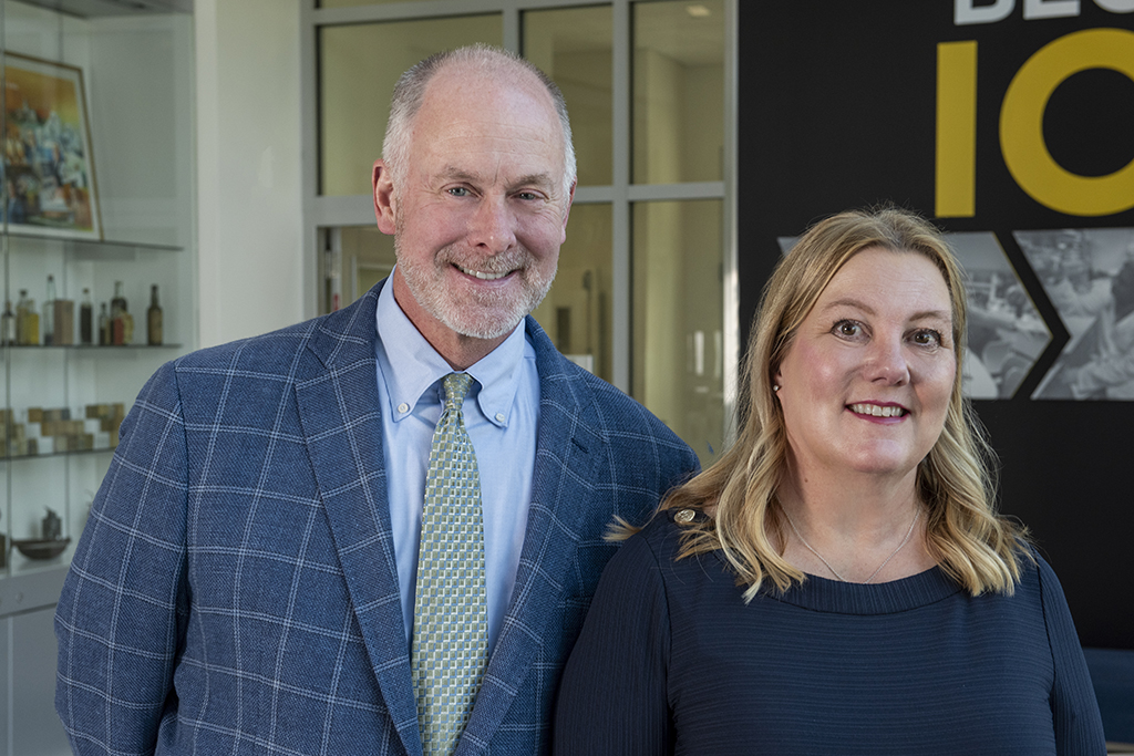 Lee Vermeulen and Jill Kolesar pose for a photo in front of a building