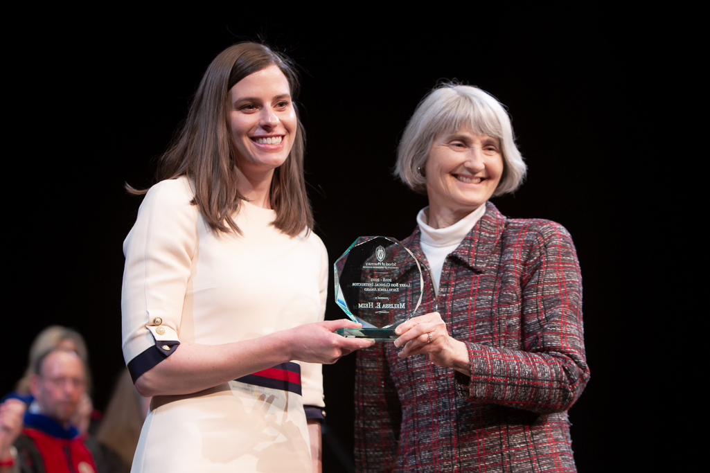 Melissa Heim accepts the award from mara Kieser, assistant dean of the School of Pharmacy.