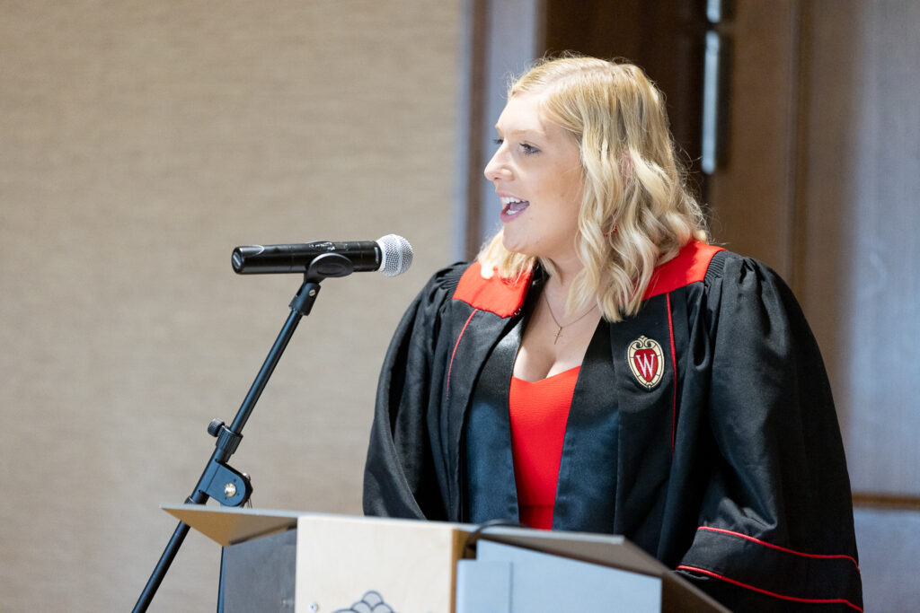 A PharmTox graduate speaks at the podium.