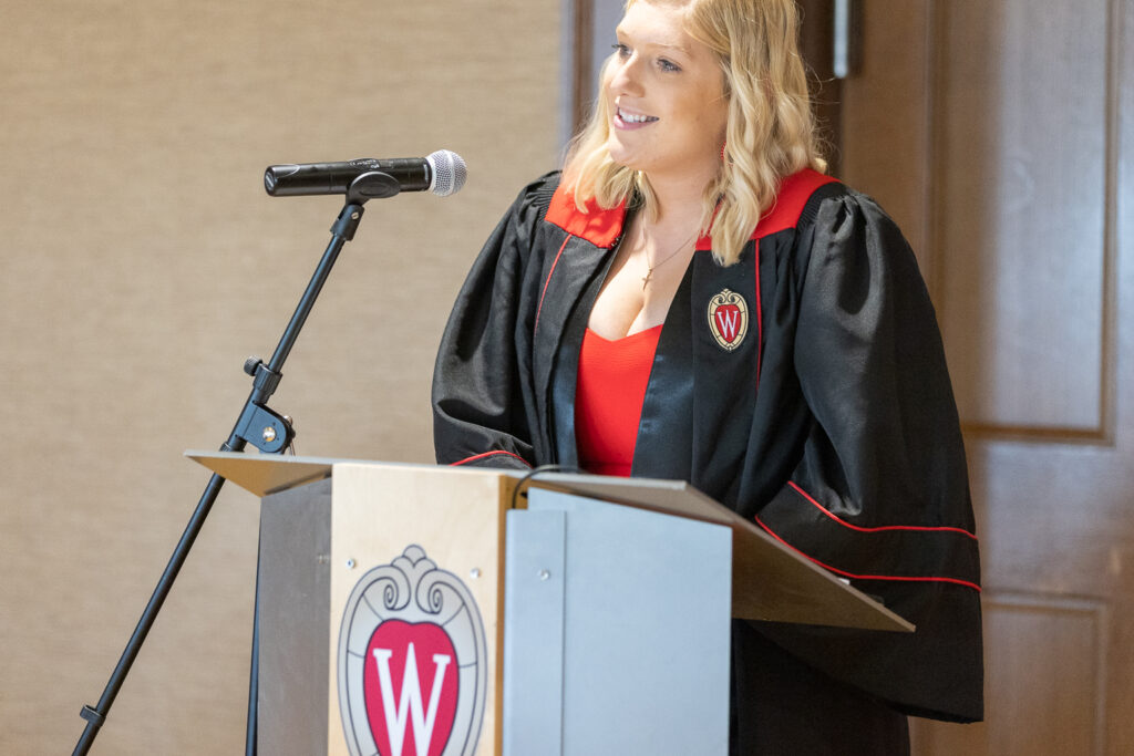 A PharmTox graduate speaks at the podium.