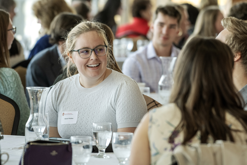 Camera focused on Alyssa Pankau sitting around the table with blurry students