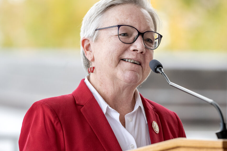 Jeanette Roberts smiling and speaking into microphone at podium