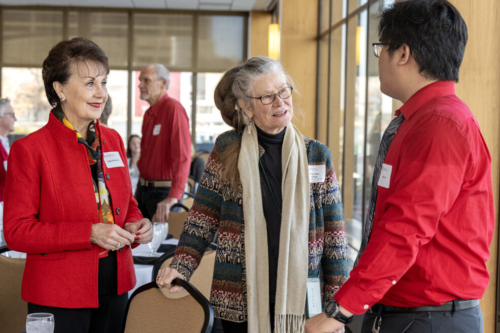 Betty Chewning speaking to Steven Do with Peggy Wiederholt listening attentively