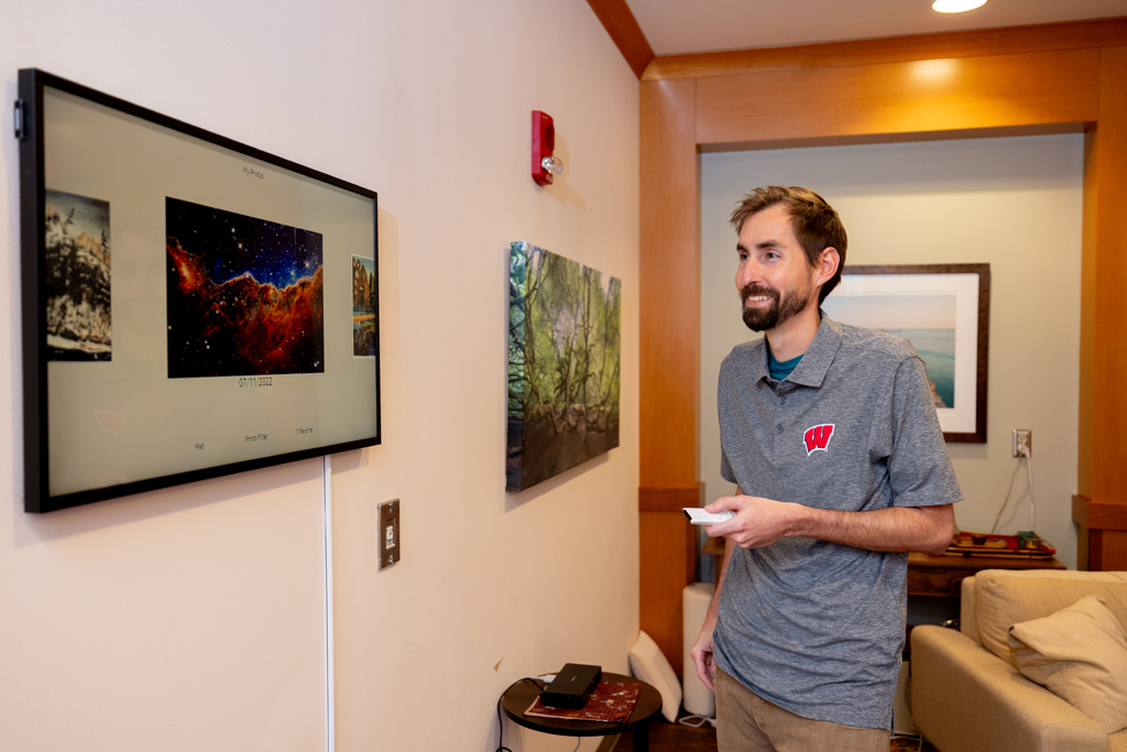 Wenthur selects a photo from a digital display in the School of Pharmacy’s psychedelic-assisted therapy space.