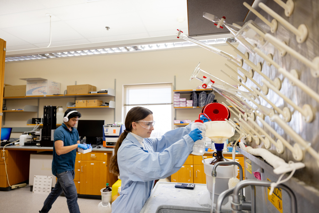 Noelle Cataldo, a graduate student in the Molecular and Cellular Pharmacology Training Program, rinses off a pair of forceps. 