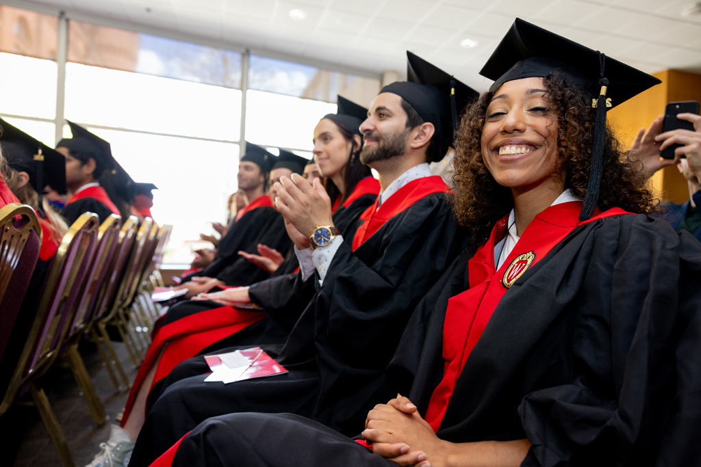 Graduates listen to speakers and clap