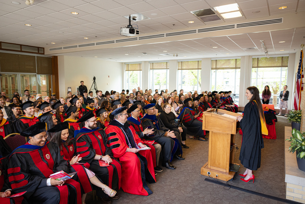 Graduate Mika Hess speaks at the podium