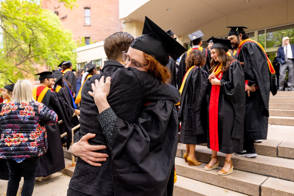 A graduate and family embrace