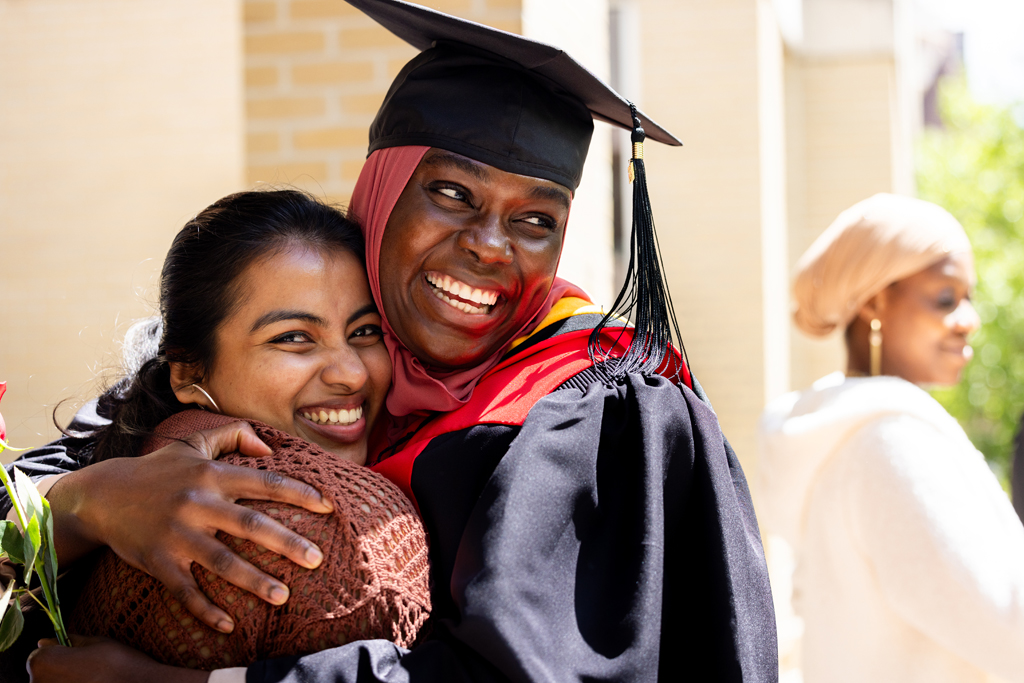 Graduates smile outside