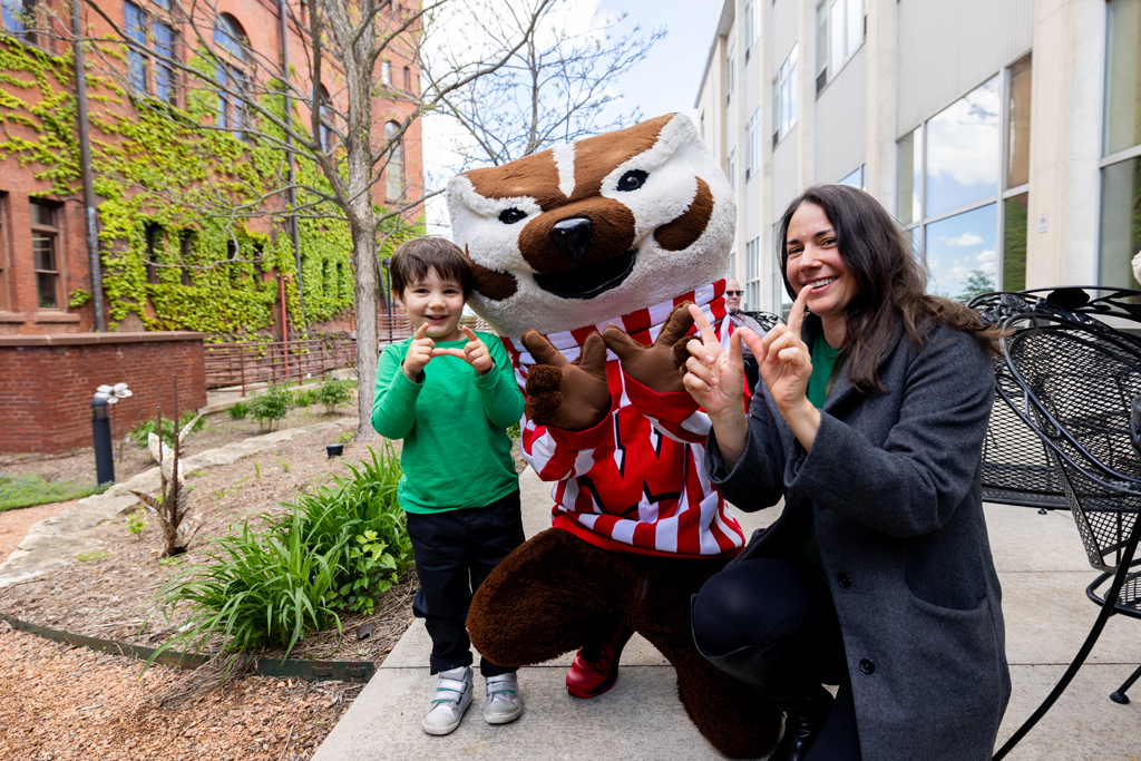 A graduate poses with Bucky Badger