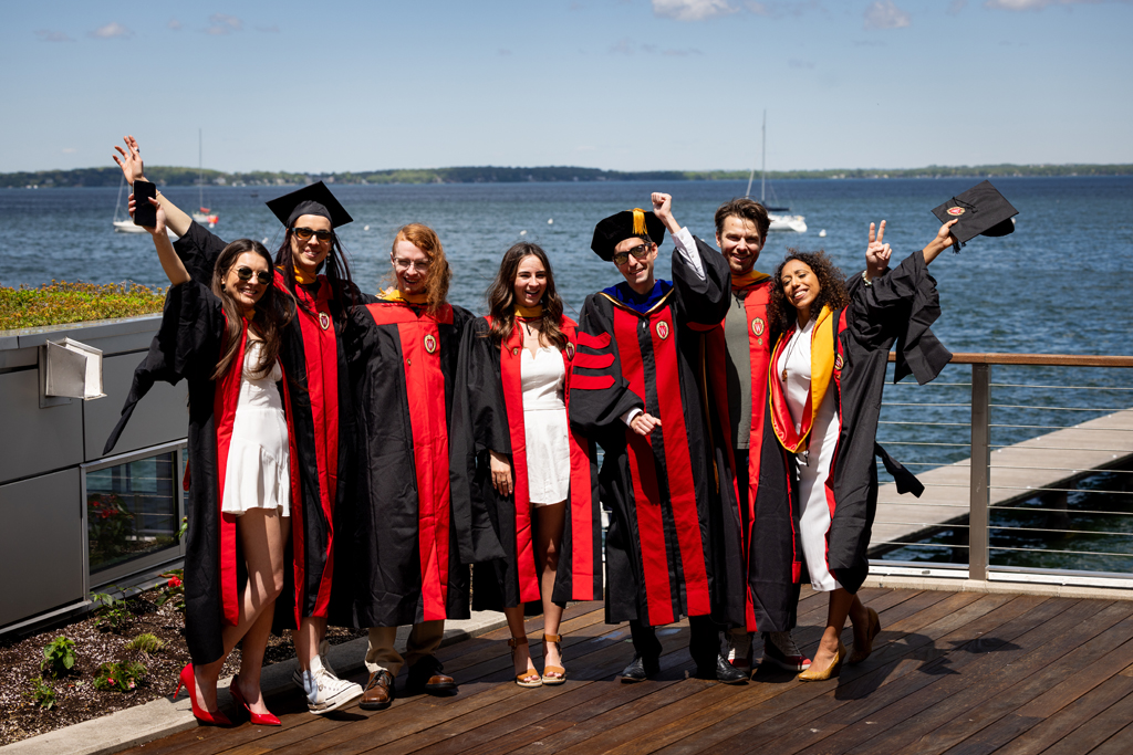 A group of graduates smile outside