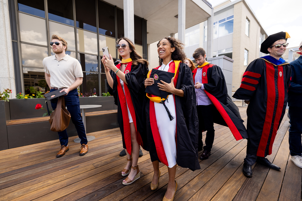 Graduates smile outside