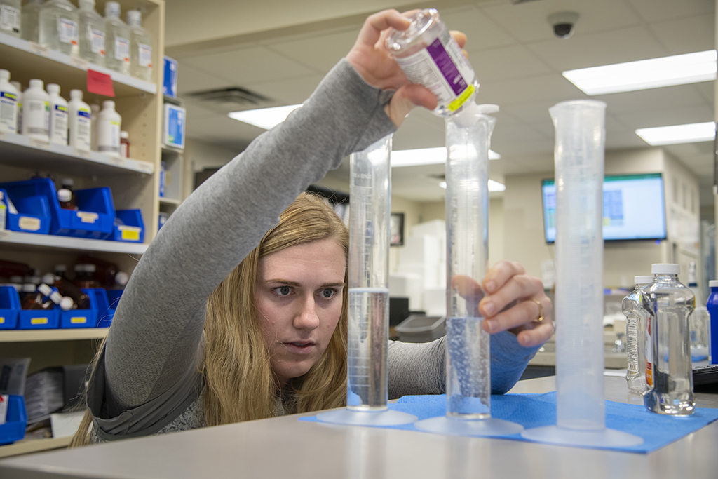 Rachel Jenson pours a liquid.