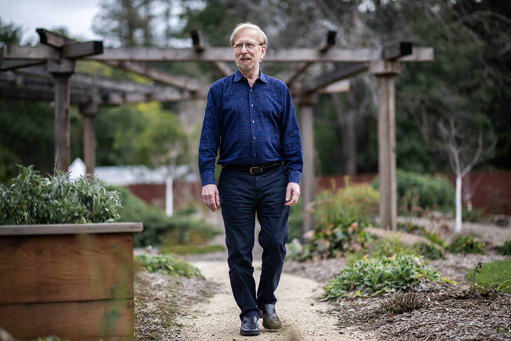 Russ Lehrman walking under a pergola.