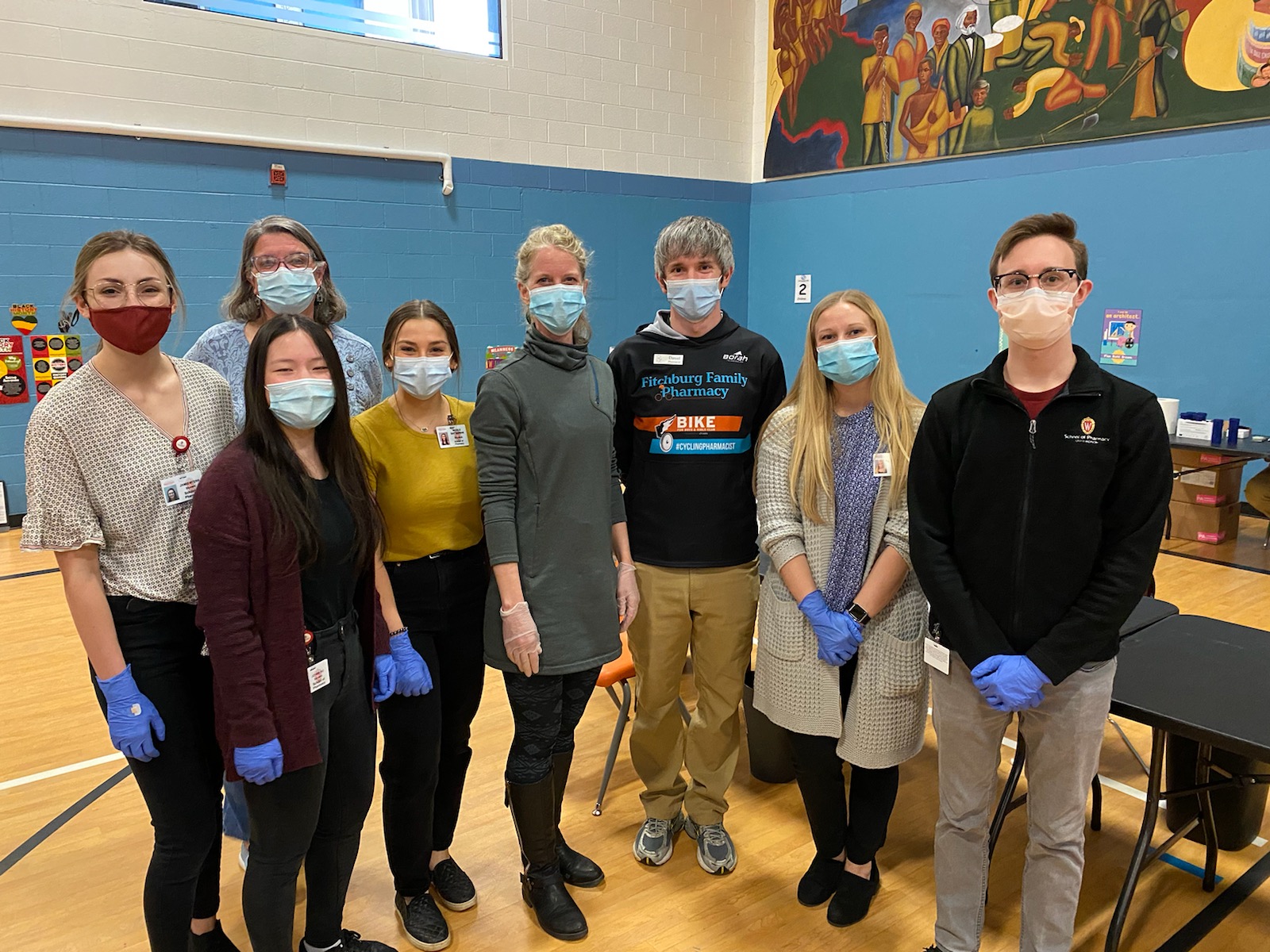 School of pharmacy volunteers standing with masks and gloves in the Boys & Girls Taft Club small gym