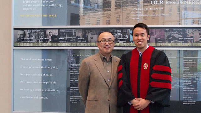 Glen Kwon standing with Tony Tam wearing graduation robes
