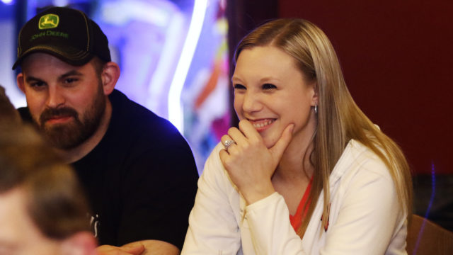 Alumni laughing and smiling with drinks in front of them