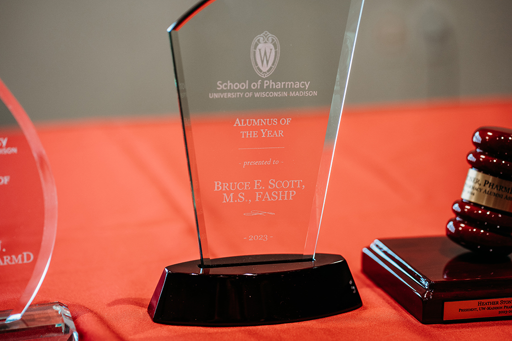 The glass trophy engraved with "2023 Alumnus of the Year Bruce Scott"