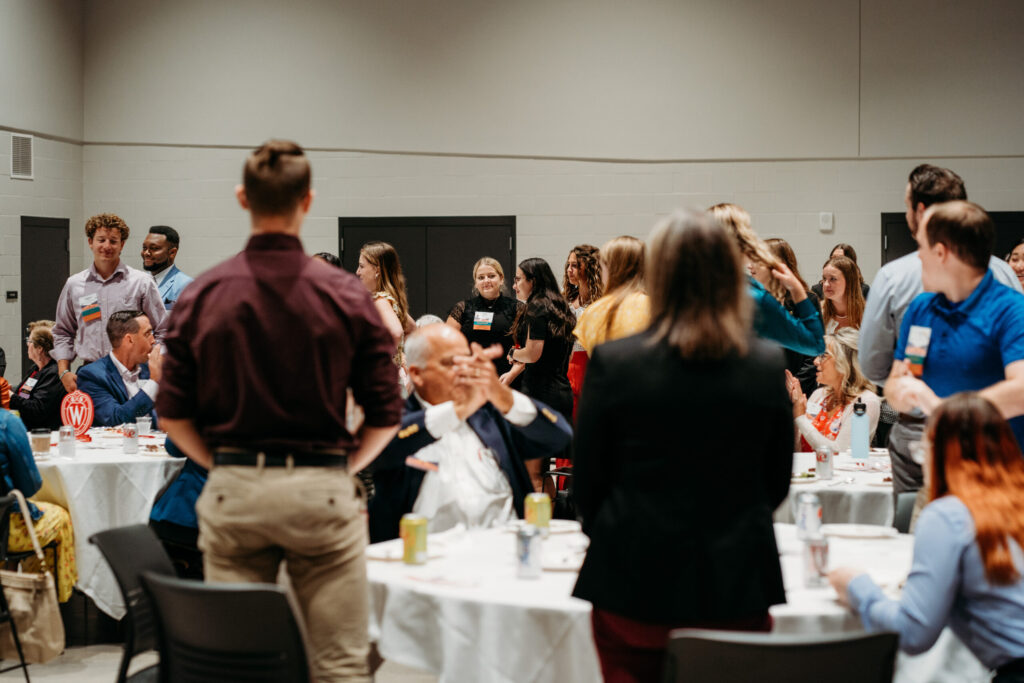 Alumni standing and sitting around the room.