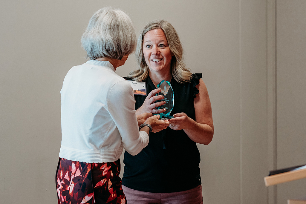 Mara Kieser hands Amy Kulig an award