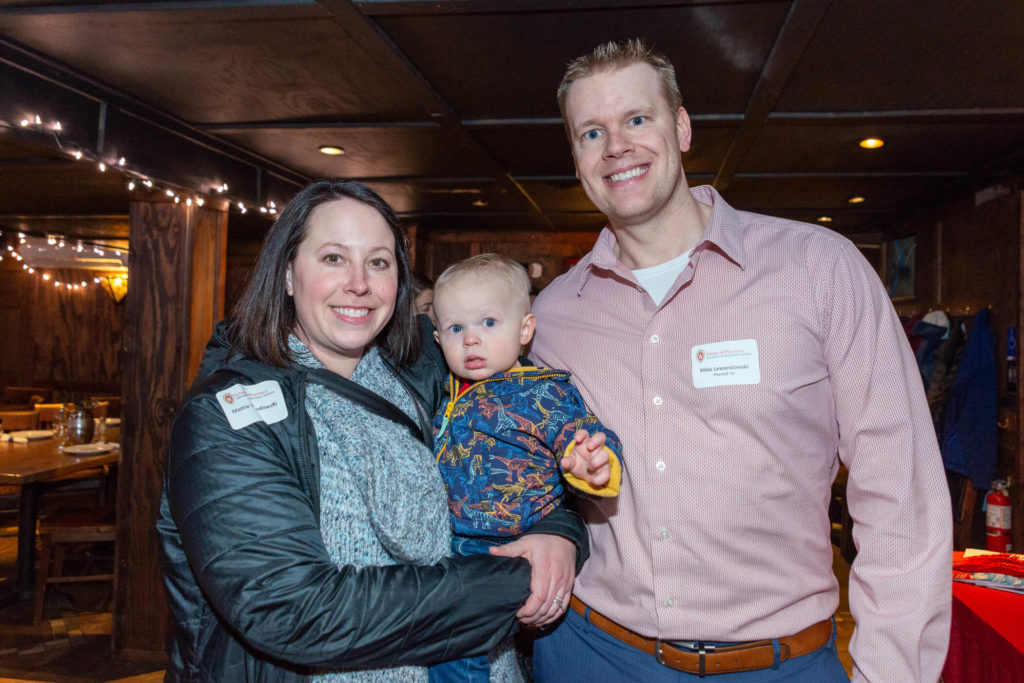 Mattie and Mike Lewandowski with their baby whom is wearing dinosaur print