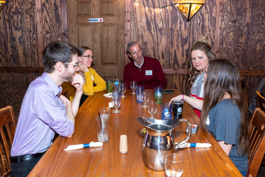 Dave Mott sitting at table with Pharmacy Alumni with drinks in front of them