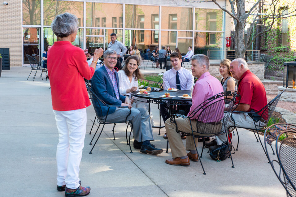 Students and their family eating around tables