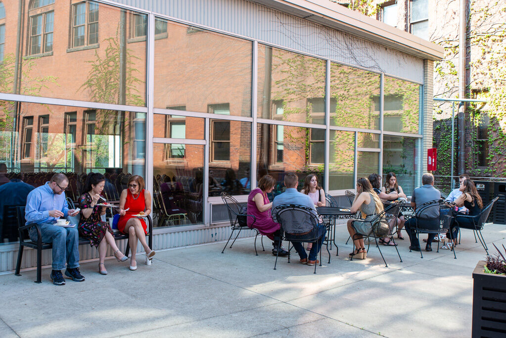 People eating outdoors at tables and benches