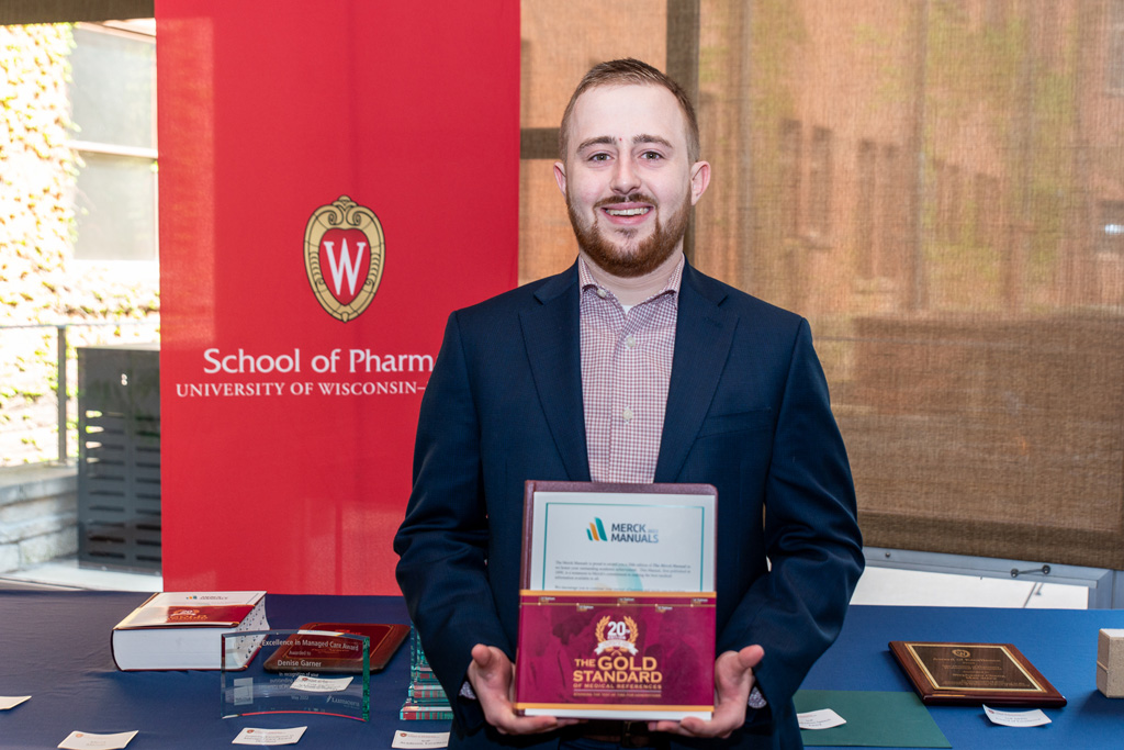 UW Pharm Award recipient holding the Merck Manual