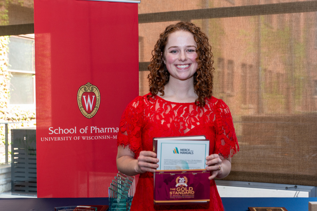 UW Pharm Award recipient holding the Merck Manual