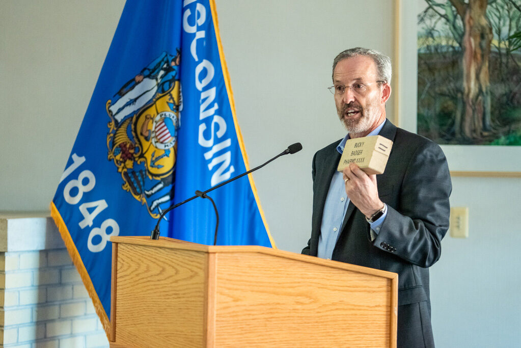 Dave Mott holding up a brick at podium