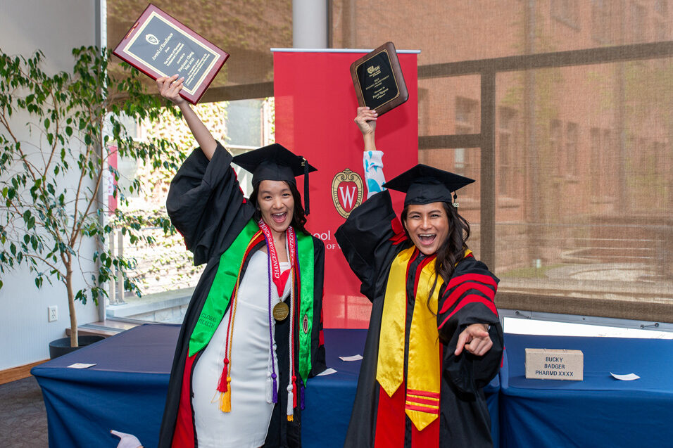 Graduated students holding their awards in the air