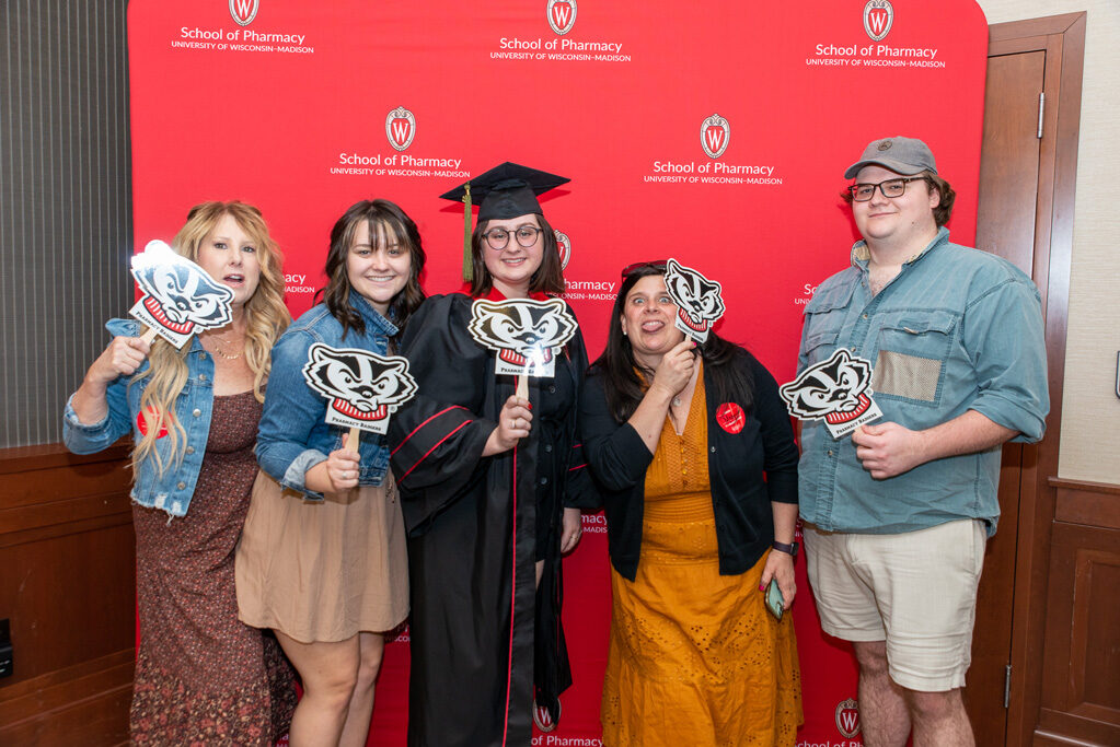 PharmTox student with her family in front of red backdrop