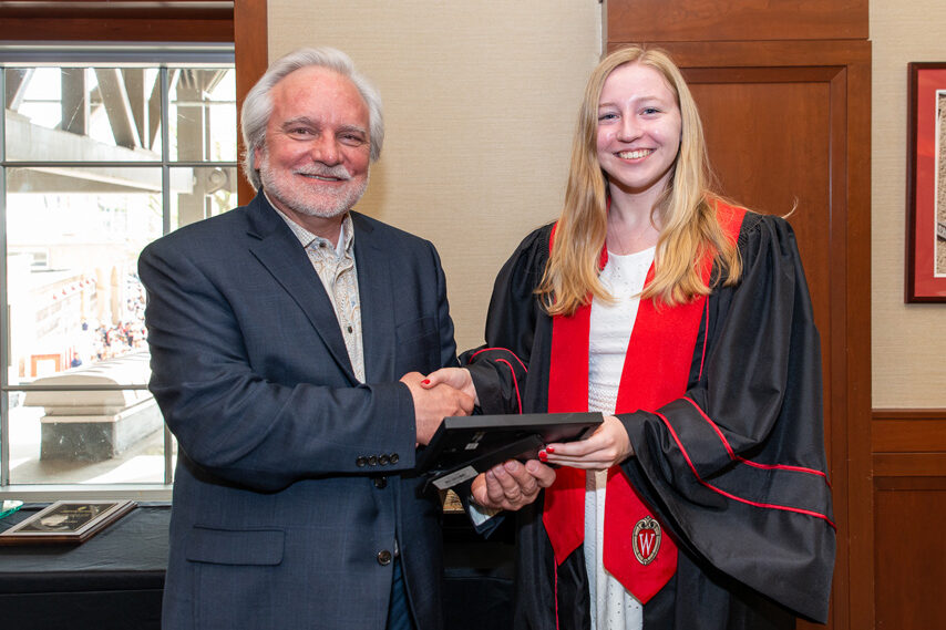 Graduate student holding a picture frame with prof. Jeffrey Johnson