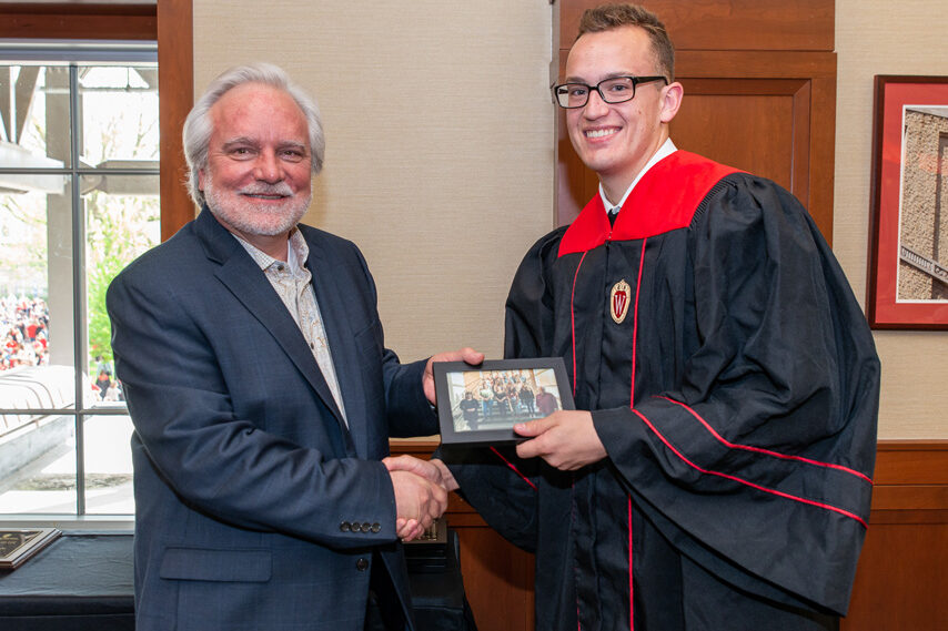 Graduate student holding a picture frame with prof. Jeffrey Johnson