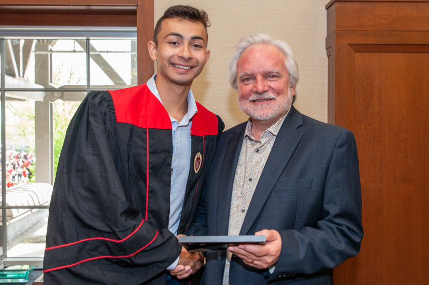 Graduate student holding a picture frame with prof. Jeffrey Johnson