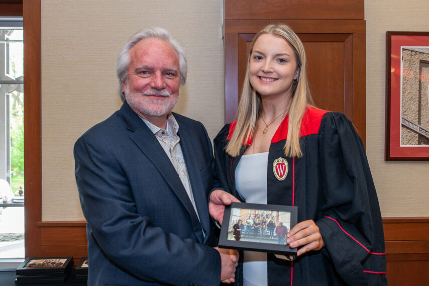 Graduate student holding a picture frame with prof. Jeffrey Johnson