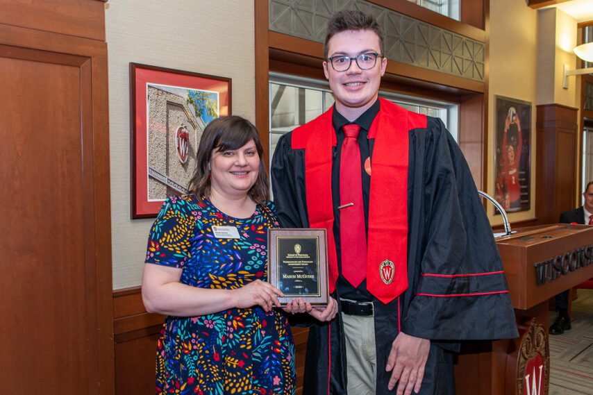 graduate student with faculty member holding an award