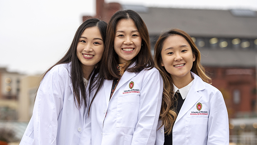 Three PharmD students outside of Memorial Union after the White Coat ceremony.